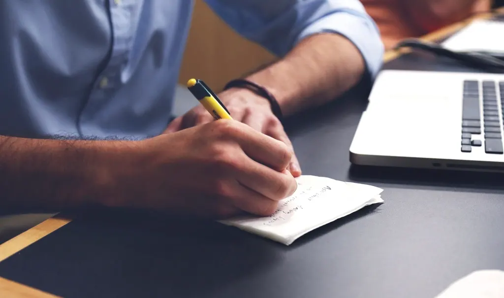 Business tagline ideas being written by hand on paper