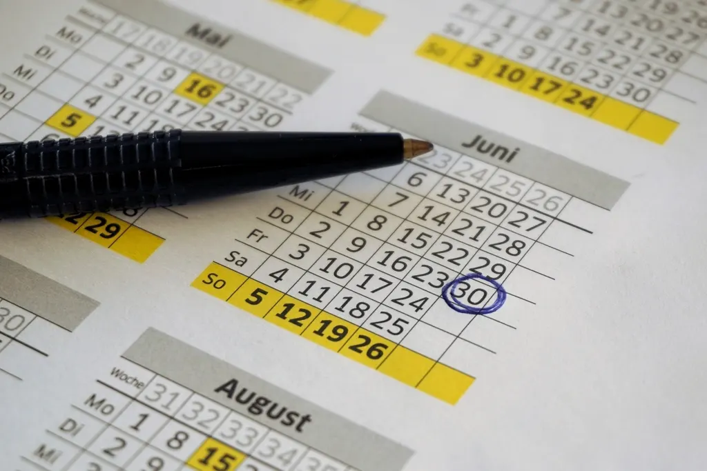 Content calendar: a pen resting on a printed monthly calendar with dates circled