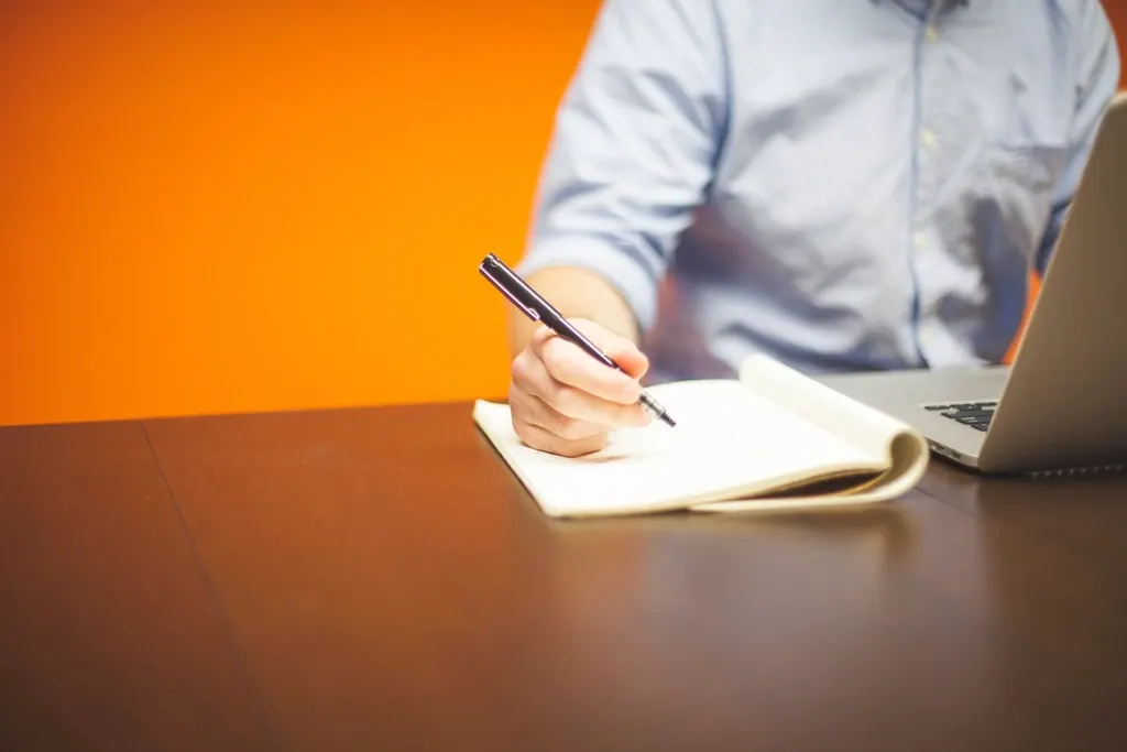Write a case study from notes: a person writing in a notebook at a desk